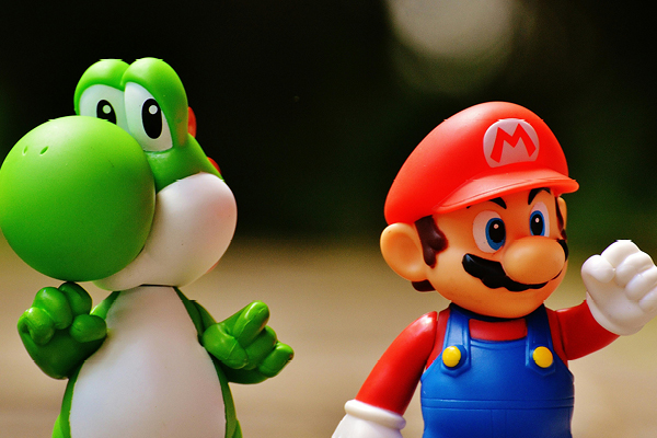 Des personnages de jeu vidéo en figurine sont pris en photo. On y voit les célèbres Mario et Yoshi, du développeur Nintendo